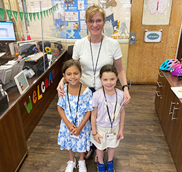Principal with two happy students in her office