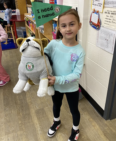 Student holding stuffed animal mascot