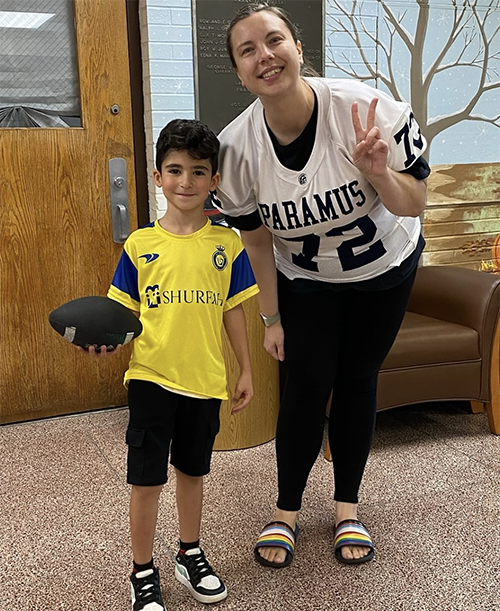 Parkway Elementary School fourth grade teacher, Ms. Alix Hunter with elementary student holding football