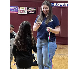 female aid with one student reading a note