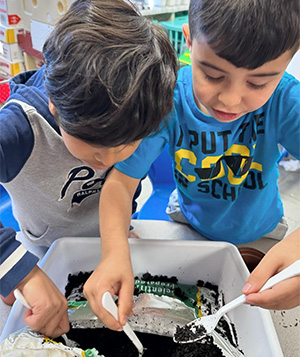 two students digging in dirt